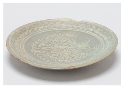 a plate with impressed and inlaid fish patterns