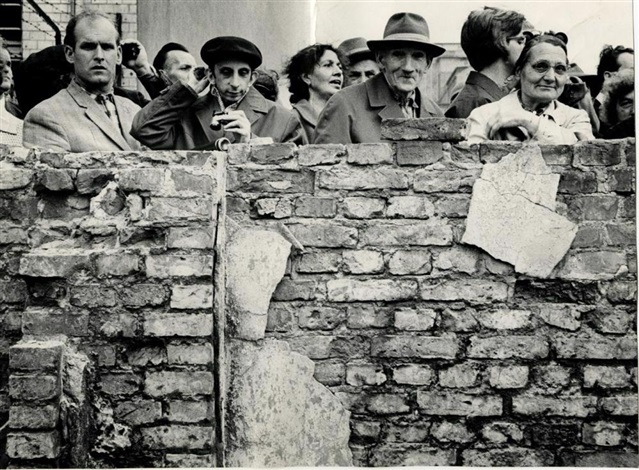 West Berliners looking into E. Berlin from a ruined building near the