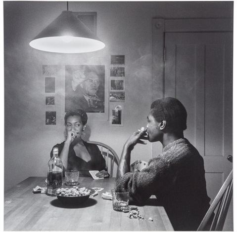 A black and white photograph of two Black people smoking at a kitchen table